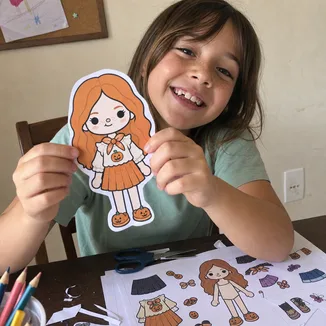 Menina mostrando bonecas de papel 1